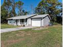 Gray home with a two-car garage and a paved driveway at 3261 Rogue St, North Port, FL 34291