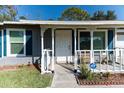 Inviting front porch with white railings, a welcome sign, and a view of the home's entrance at 3261 Rogue St, North Port, FL 34291