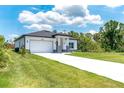 Beautiful single-story home features a well-manicured lawn, long driveway, and attached two car garage at 398 Sunset N Rd, Rotonda West, FL 33947