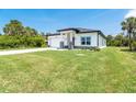 Spacious front yard featuring a well manicured lawn, long driveway, and attached two car garage at 398 Sunset N Rd, Rotonda West, FL 33947