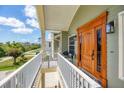 Inviting front porch features a wood front door, painted rails, and relaxing outdoor furniture at 4219 Spire St, Port Charlotte, FL 33981