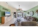Spacious living room with high ceilings, tile flooring, and sliding door access to lanai at 4225 Fairway Dr, North Port, FL 34287