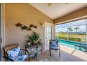 Cozy outdoor seating area on screened lanai with golf course and pool view at 4225 Fairway Dr, North Port, FL 34287