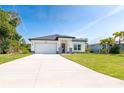 Attractive one-story house boasts a modern design, manicured lawn, and attached two-car garage at 482 Sunset N Rd, Rotonda West, FL 33947