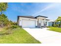 Beautiful one-story home with lush lawn, attached two-car garage, and well-maintained landscaping at 482 Sunset N Rd, Rotonda West, FL 33947