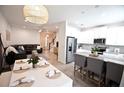 Open-concept living space with modern kitchen, dining area, and comfortable seating area under decorative lighting at 5009 Skyview Ln, Bradenton, FL 34211