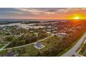 Aerial view of a coastal home near the ocean with lush landscaping at sunset at 530 Spaniards Rd, Placida, FL 33946