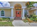 Inviting front entrance featuring a bright door, elegant columns, and lush landscaping, creating a warm welcome at 59 White Marsh Ln, Rotonda West, FL 33947