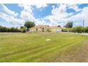 Spacious front lawn view of a single story home with a side entry garage under a beautiful blue sky at 6158 Cavan St, Englewood, FL 34224