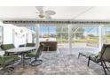 Relaxing screened patio features a hot tub, dining table, ceiling fan, and outdoor seating area at 7048 Inland St, Englewood, FL 34224