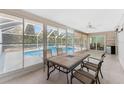 Enclosed patio featuring tile flooring, ceiling fan, and backyard pool view at 7247 Brookhaven Ter, Englewood, FL 34224