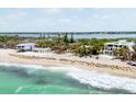 Stunning beachfront homes with palms, soft sand, and inviting turquoise waters, perfect for coastal living at 7420 Manasota Key Rd, Englewood, FL 34223