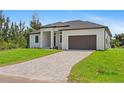 New home with a paved driveway, manicured lawn, and a two-car garage at 8105 Antwerp Cir, Port Charlotte, FL 33981
