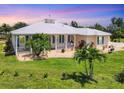 Charming home featuring a welcoming front porch, manicured lawn, and vibrant landscaping at 8127 Consul St, Port Charlotte, FL 33981