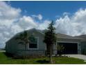 Charming single-story home with a modern exterior, well-manicured lawn, and inviting curb appeal under a bright blue sky at 8360 Waterscape Rd, Englewood, FL 34224