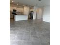Modern kitchen with stainless steel appliances, white cabinetry and a center island at 8360 Waterscape Rd, Englewood, FL 34224