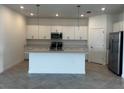Spacious kitchen featuring a center island, modern appliances, and ample countertop space at 8360 Waterscape Rd, Englewood, FL 34224