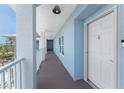 Outdoor hallway featuring blue walls and a white entry door at 8405 Placida Rd # 406, Placida, FL 33946