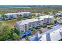 Aerial view of multi-story condominium complex with water views, mature palms and covered parking at 8411 Placida Rd # 404, Placida, FL 33946