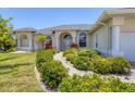 Charming home exterior featuring a well-manicured garden pathway, elegant arched entryway, and classic architectural details at 1002 Rotonda Cir, Rotonda West, FL 33947