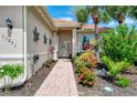 Charming front entrance with brick path and lush landscaping with a decorative wreath at 13051 Creekside Ln, Port Charlotte, FL 33953