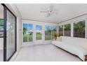 Enclosed sunroom with tile flooring, large windows providing serene views of the backyard at 1337 Le Pera Rd, Englewood, FL 34223