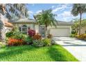 Charming home featuring lush landscaping, a tile roof, and a well-manicured lawn at 13376 Golf Pointe Dr, Port Charlotte, FL 33953