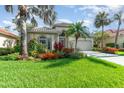 Charming home featuring lush landscaping, a tile roof, and a well-manicured lawn at 13376 Golf Pointe Dr, Port Charlotte, FL 33953