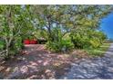 A long brick driveway leads to the house, nestled among lush trees and greenery at 1550 Bayshore Dr, Englewood, FL 34223
