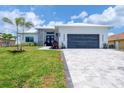 Beautiful single-story home with a lush green lawn, stone accents, and a gray paved driveway at 15610 Staunton Cir, Port Charlotte, FL 33981