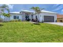 Beautiful single-story home with a lush green lawn, stone accents, and a gray paved driveway at 15610 Staunton Cir, Port Charlotte, FL 33981