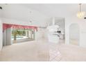 Bright living room featuring tile flooring, a ceiling fan, and views into the kitchen and outdoor pool area at 18112 Windswept Av, Port Charlotte, FL 33948