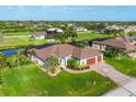 An elevated view showcasing the home's landscaping, backyard canal, screen enclosed pool, and neighborhood at 204 W Pine Valley Ln, Rotonda West, FL 33947