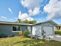 Inviting exterior features a well maintained lawn and colorful flower beds surrounding the house's front entrance at 21519 Fairway Ave, Port Charlotte, FL 33952
