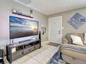 Cozy living area features tile flooring, a plush couch, and a large screen TV for entertainment at 21519 Fairway Ave, Port Charlotte, FL 33952