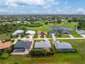 A tranquil aerial view showcases this idyllic neighborhood near a golf course and a shimmering lake at 22 Par View Rd, Rotonda West, FL 33947