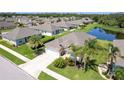 Aerial view of a home with manicured landscaping near a pond in a residential neighborhood at 267 Talquin Ct, Englewood, FL 34223