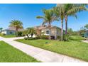 Well-maintained home with manicured lawn, landscaping, and mature palm trees at 267 Talquin Ct, Englewood, FL 34223