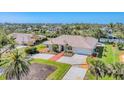 Charming Florida home features manicured lawn, palm trees, a brick-accented driveway, and a vibrant blue front door at 285 Spaniards Rd, Placida, FL 33946