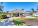 Beautiful home with manicured landscaping and palm trees, featuring a brick-accented driveway and welcoming blue door at 285 Spaniards Rd, Placida, FL 33946