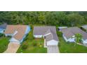 An aerial view of a well-maintained home with lush landscaping and a serene setting amongst mature trees at 399 Blue Springs Ct # 203, Englewood, FL 34223