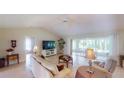 Inviting living room with tiled flooring, ceiling fan and access to a screened lanai with abundant natural light at 399 Blue Springs Ct # 203, Englewood, FL 34223