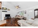 Bright living room with hardwood floors, a ceiling fan, comfortable seating, and natural lighting at 4399 Mundella Cir, Port Charlotte, FL 33948