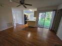 Bright living room with hardwood floors, leading to the kitchen and an outdoor patio at 4900 Hurley Ave, North Port, FL 34288
