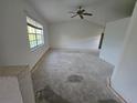 Spacious living room featuring a large window providing natural light and ceiling fan at 4900 Hurley Ave, North Port, FL 34288