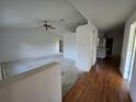 Open-concept living room featuring a ceiling fan and transitions to the kitchen with hardwood flooring at 4900 Hurley Ave, North Port, FL 34288