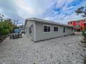 Rear view of the home with a shell-covered yard perfect for outdoor entertaining at 608 Saint Judes Dr, Longboat Key, FL 34228