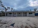 Inviting single-story home with a covered front porch and a shell-covered yard at 608 Saint Judes Dr, Longboat Key, FL 34228