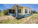 The side exterior view shows a screened-in porch and garden bed with a light-yellow mobile home at 6293 Sparrow Ln, Englewood, FL 34224
