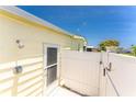 Side-view image displaying an outdoor shower and back entrance for a yellow home at 6293 Sparrow Ln, Englewood, FL 34224